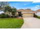 Charming single-story home with well-manicured lawn, mature trees, and a two-car garage at 12710 Rockrose Gln, Lakewood Ranch, FL 34202