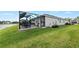 Spacious backyard featuring screened-in patio with outdoor dining area, green grass, and beautiful landscaping at 12726 Rainwashed Loop, Parrish, FL 34219