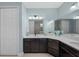 Bright bathroom with dark wood cabinets, quartz countertop, framed mirror, and linen closet at 12726 Rainwashed Loop, Parrish, FL 34219