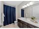 Bathroom featuring a dark wood cabinet, quartz countertop, framed mirror, and blue shower curtain at 12726 Rainwashed Loop, Parrish, FL 34219