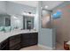 Bright bathroom with dark wood cabinets, quartz countertop, framed mirror, and glass-enclosed shower at 12726 Rainwashed Loop, Parrish, FL 34219