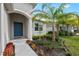Welcoming front entrance with a blue door, lush landscaping, and vibrant flowers, creating a warm and inviting curb appeal at 12726 Rainwashed Loop, Parrish, FL 34219