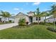 Charming home featuring a well-kept lawn and tropical landscaping, enhancing its curb appeal and inviting atmosphere at 12726 Rainwashed Loop, Parrish, FL 34219