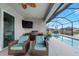 Outdoor screened-in patio with comfortable seating, built-in grill and summer kitchen with a relaxing pool view at 12726 Rainwashed Loop, Parrish, FL 34219