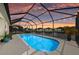 Relaxing screened-in pool overlooking a tranquil waterfront view, creating a private outdoor oasis at sunset at 12726 Rainwashed Loop, Parrish, FL 34219