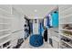 Large walk-in closet with custom shelving, hanging rods, and a central ottoman at 12726 Rainwashed Loop, Parrish, FL 34219
