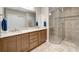 Primary bathroom with double sink vanity, tiled walk-in shower, and private toilet area at 130 Bella Vista Ter # 10A, Nokomis, FL 34275