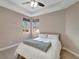 Comfortable bedroom with two windows, neutral walls, plush carpet, and a ceiling fan at 130 Bella Vista Ter # 10A, Nokomis, FL 34275