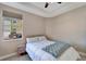 Bright bedroom featuring neutral walls, plush carpet, a ceiling fan, a window, and a nightstand at 130 Bella Vista Ter # 10A, Nokomis, FL 34275