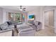 Comfortable living room with plush seating, a ceiling fan, and access to outdoor views at 130 Bella Vista Ter # 10A, Nokomis, FL 34275