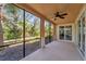 Spacious screened porch with lush landscaping views and ceiling fan, perfect for relaxation at 130 Bella Vista Ter # 10A, Nokomis, FL 34275