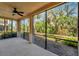 Screened porch features a ceiling fan and serene views of the lush surroundings at 130 Bella Vista Ter # 10A, Nokomis, FL 34275