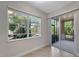 Bright sunroom with window and sliding glass door to screened patio offers lush outdoor views at 130 Bella Vista Ter # 10A, Nokomis, FL 34275