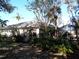 Backyard showcasing the home's exterior, screened-in lanai, and mature landscaping at 1354 Tearose Pl, Sarasota, FL 34239