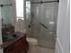 Bathroom vanity featuring dark wood vanity with decorative sink and glass door shower at 1354 Tearose Pl, Sarasota, FL 34239