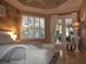 Bright bedroom with tile floor, brick accent wall, tray ceiling, and door to the outside at 1354 Tearose Pl, Sarasota, FL 34239
