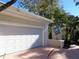 Spacious two-car garage with brick paved driveway and manicured landscaping at 1354 Tearose Pl, Sarasota, FL 34239