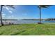 Scenic backyard with well-maintained lawn and waterfront views featuring swaying palm trees at 1444 Ridgewood Ln, Sarasota, FL 34231