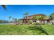 Beautiful waterfront home with lush landscaping, deck, and mature palm trees on a sunny day at 1444 Ridgewood Ln, Sarasota, FL 34231