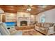 Cozy living room features a stone fireplace and wood-paneled ceiling at 1444 Ridgewood Ln, Sarasota, FL 34231