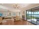 Open-concept living room with water views, chandelier, and sliding door to the deck at 1444 Ridgewood Ln, Sarasota, FL 34231