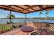 Outdoor patio features waterfront views, a dining table, and an outdoor bar area perfect for entertaining at 1444 Ridgewood Ln, Sarasota, FL 34231