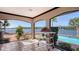 Relaxing sunroom features stunning water views, pool access, tile flooring, and plenty of natural light at 1444 Ridgewood Ln, Sarasota, FL 34231