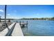 Beautiful waterfront view with a concrete walkway leading to a private wooden dock, perfect for enjoying the water at 1444 Ridgewood Ln, Sarasota, FL 34231