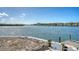 Scenic waterfront view with a wooden dock, calm waters, and lush greenery in the background on a beautiful day at 1444 Ridgewood Ln, Sarasota, FL 34231