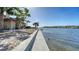 Stunning waterfront property featuring a concrete walkway, lush landscaping, and serene water views on a sunny day at 1444 Ridgewood Ln, Sarasota, FL 34231