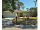 Charming single-story home with a well-manicured front yard, two-car garage, and lush landscaping at 1805 Springwood Dr, Sarasota, FL 34232