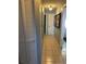 Hallway features neutral tile flooring, a closet, and artwork, leading to a bright entrance at 1805 Springwood Dr, Sarasota, FL 34232