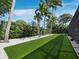 A well-manicured backyard features lush green grass, mature trees, and thoughtful landscaping at 1909 Field Rd, Sarasota, FL 34231
