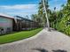 Backyard with an enclosed pool, artificial grass, and lush tropical landscaping creating a private oasis at 1909 Field Rd, Sarasota, FL 34231