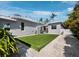 Landscaped backyard featuring artificial turf, stone pathways, and a clean, modern exterior design at 1909 Field Rd, Sarasota, FL 34231