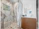 Modern shower with marble tile surround, bench, and glass enclosure, complemented by wood-tone vanity at 1909 Field Rd, Sarasota, FL 34231