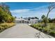 Modern home with a three-car garage, spacious driveway, surrounded by lush tropical landscaping at 1909 Field Rd, Sarasota, FL 34231
