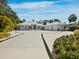 Modern home with a light gray exterior, a spacious driveway, and a three-car garage at 1909 Field Rd, Sarasota, FL 34231