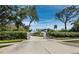 Gated entrance with a long driveway leading to a modern home surrounded by mature trees and landscaping at 1909 Field Rd, Sarasota, FL 34231
