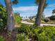 Landscaped front yard leading to a modern home with a circular driveway and lush greenery at 1909 Field Rd, Sarasota, FL 34231