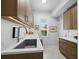 Well-lit laundry room with ample counter space and storage cabinets, offering convenience and functionality at 1909 Field Rd, Sarasota, FL 34231