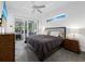 Bedroom with patio access, ceiling fan, and a modern bed with dark colored comforter at 1909 Field Rd, Sarasota, FL 34231