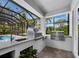 Outdoor kitchen featuring stainless steel grills, a sink, and views of the pool area at 1909 Field Rd, Sarasota, FL 34231