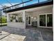 Covered outdoor kitchen featuring a stainless-steel grill, counter space, and brick flooring at 1909 Field Rd, Sarasota, FL 34231
