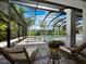 A refreshing pool is enclosed in a lanai, with stylish lounge chairs on the stone deck at 1909 Field Rd, Sarasota, FL 34231