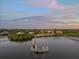 Stunning waterfront property boasts private docks and serene water views, enveloped by lush greenery under a picturesque sky at 1930 Bayshore Dr, Englewood, FL 34223