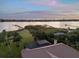 Aerial view showcases a home with a screened-in lanai and lush green lawn near the waterfront at 1930 Bayshore Dr, Englewood, FL 34223