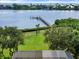 Stunning waterfront view showcasing a private dock, serene waters, and lush greenery, creating a tranquil and picturesque setting at 1930 Bayshore Dr, Englewood, FL 34223