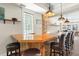 Home bar area with wood counter, pendant lighting, rustic wood siding, and leather bar stools at 1930 Bayshore Dr, Englewood, FL 34223