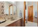 Elegant bathroom vanity with wood cabinets, neutral countertop and decorative mirror at 1930 Bayshore Dr, Englewood, FL 34223